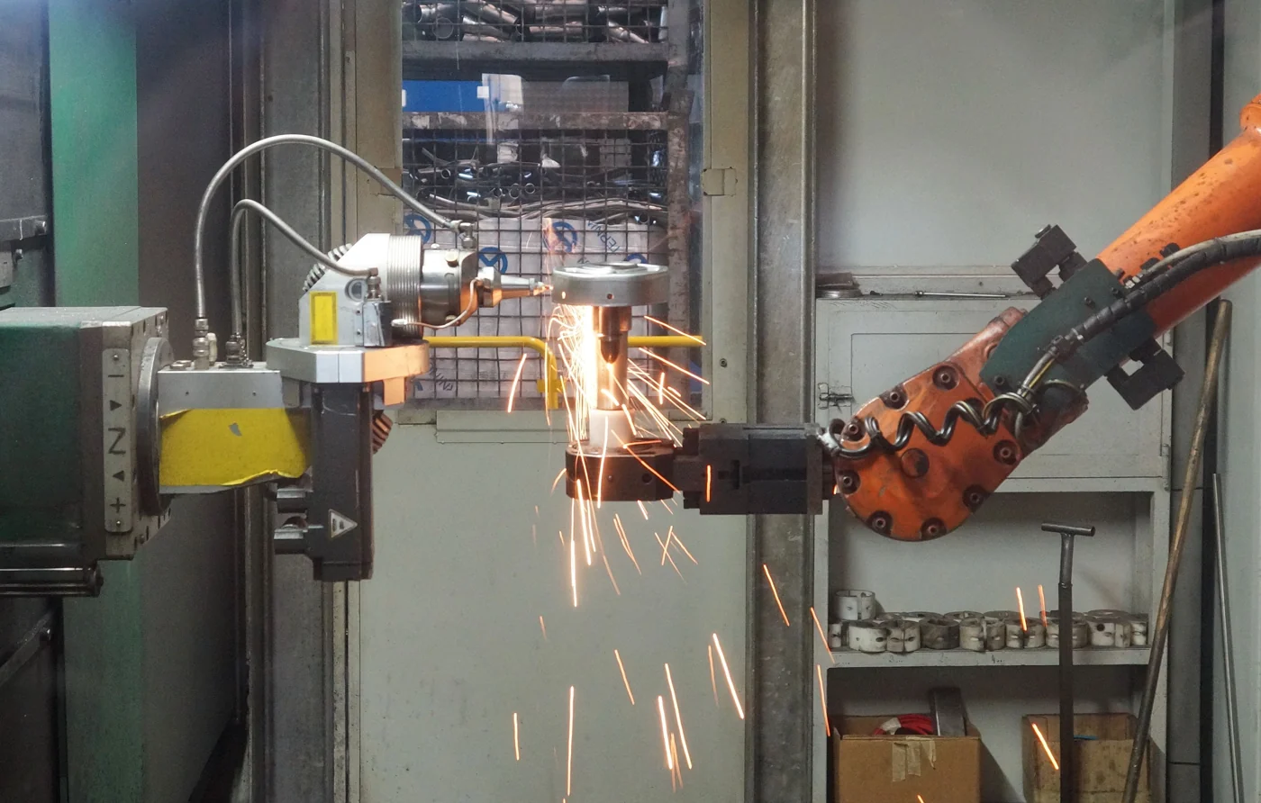 Stock photograph of a robotic arm working on a metal component